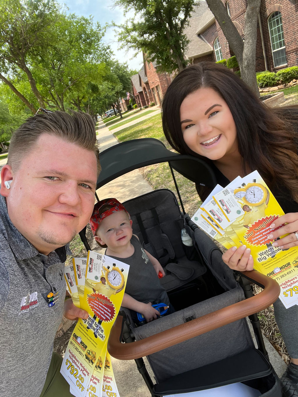 One Hour Heating and AC repair service staff and family passing out promotional material in a neighborhood. Service Dallas, Plano, Frisco, TX