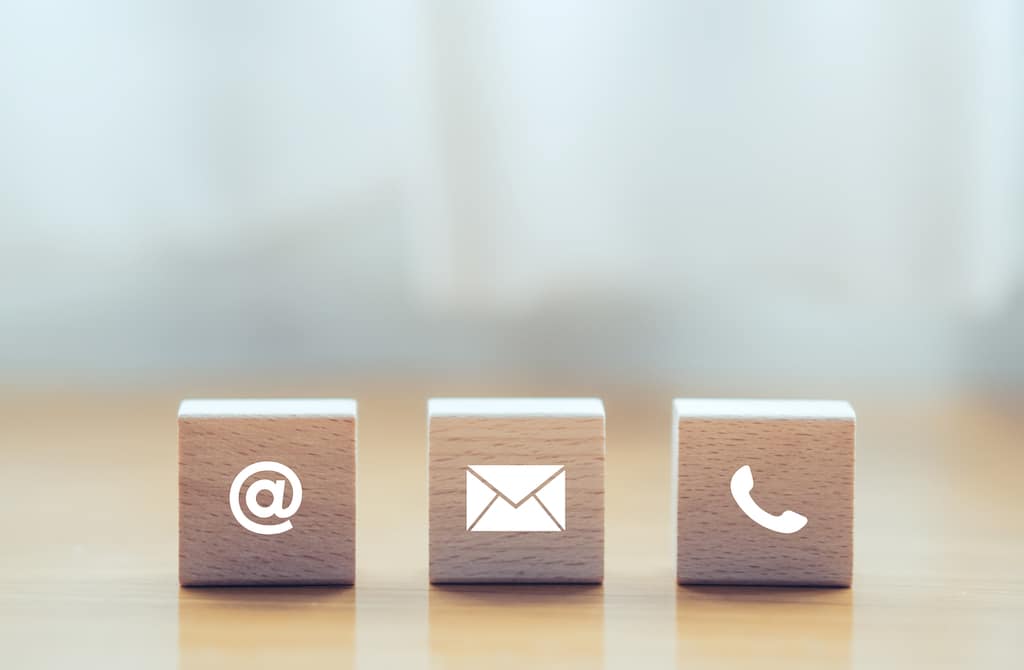 Wooden cube blocks with @ symbol, email icon, and phone icon.