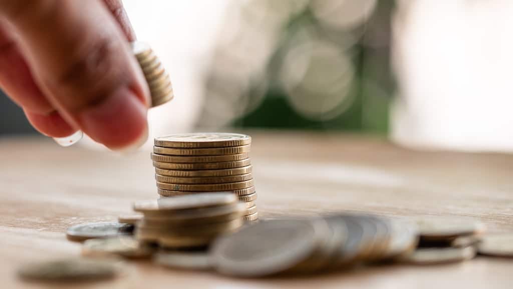 Hand holding change and stacking it with more on the table | Humidifer services in Dallas, TX