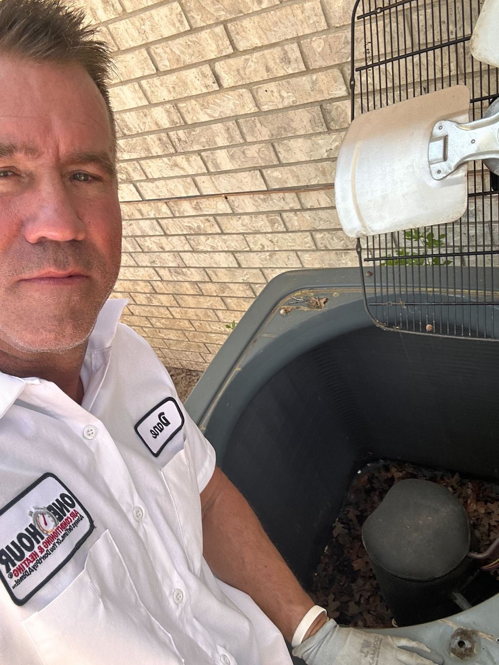 One Hour Emergency AC and Heating Repair technician servicing a customer's AC unit in Dallas, TX