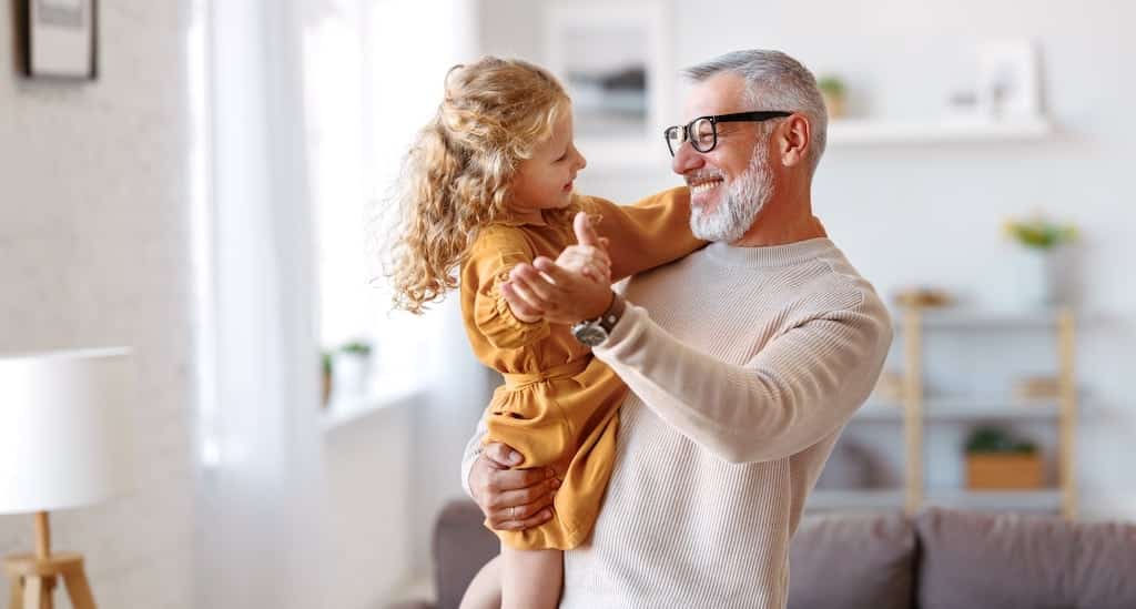 Grandfather dancing with grandaughter inside house | Thermostat Services in Dallas, Plano, and Frisco, TX