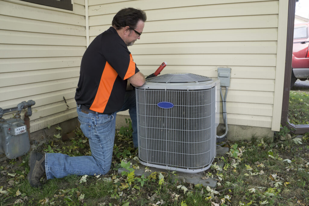 Repairman checking outside air conditioning unit  for voltage. AC Repair in Briar 