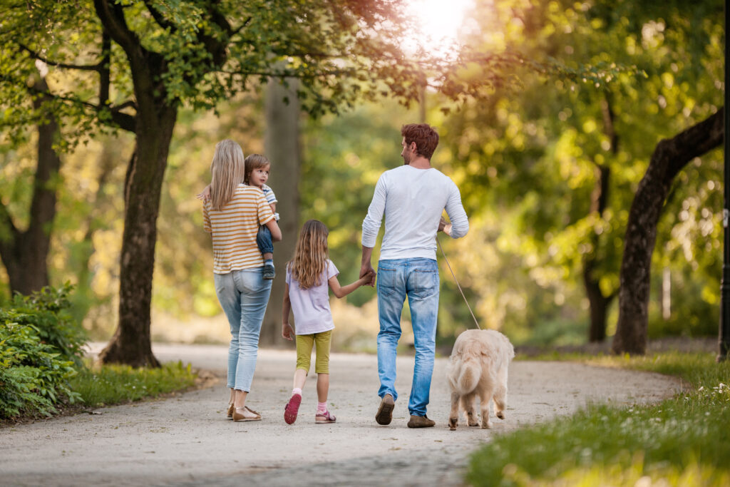 the image of a family with their dog walking in a beautiful park in Everman, TX. 
