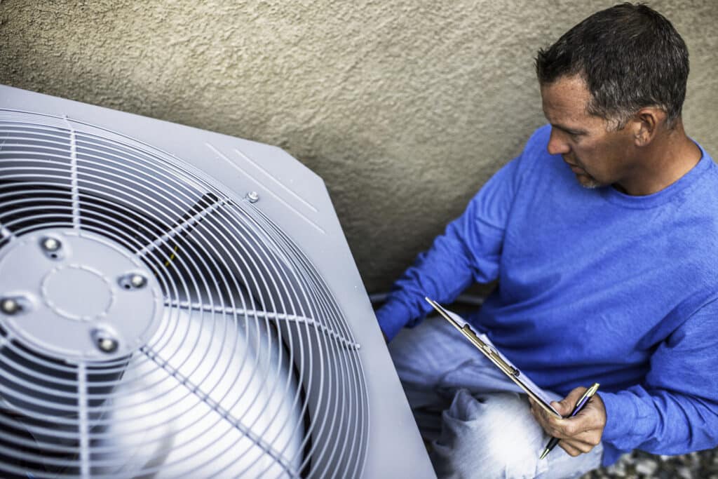 HVAC Strategies - A maintenance engineer inspecting an outdoor air conditioning unit. Residential HVAC Inspection with One Hour Air Conditioning & Heating of Dallas.