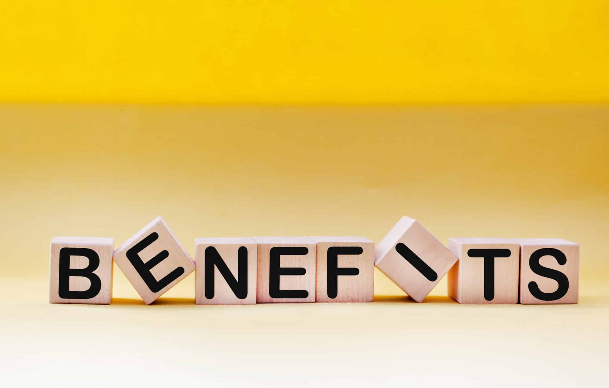 Benefits spelled out on wooden blocks against a beautiful yellow background, Thermal Imaging.