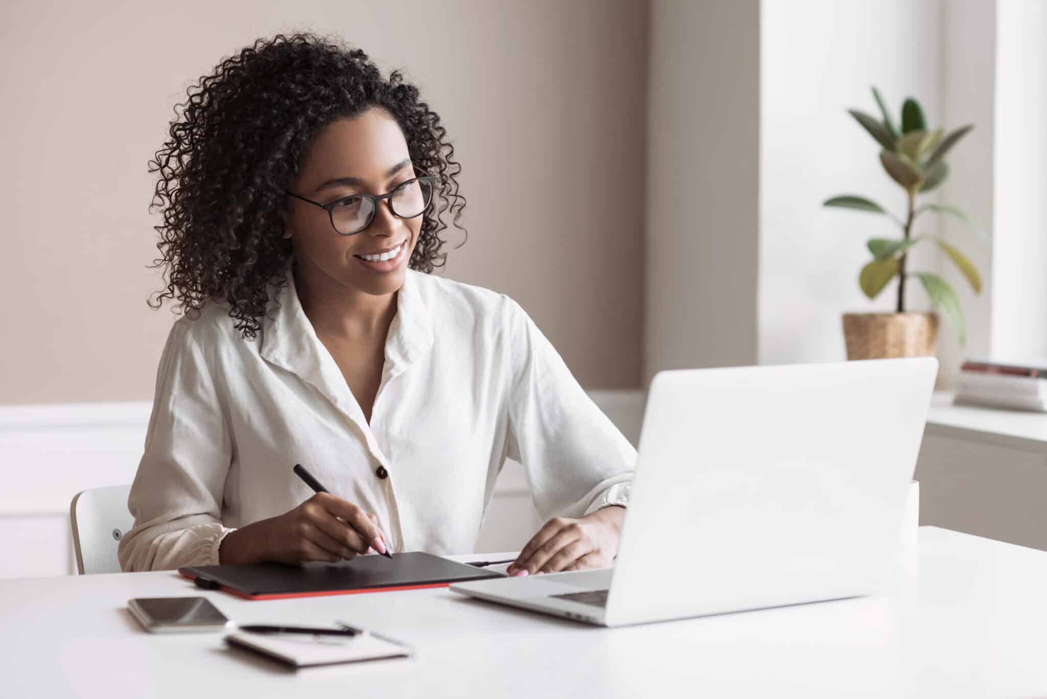 A woman working from home, enjoying comfort and focus with Silent HVAC Solutions in her room.