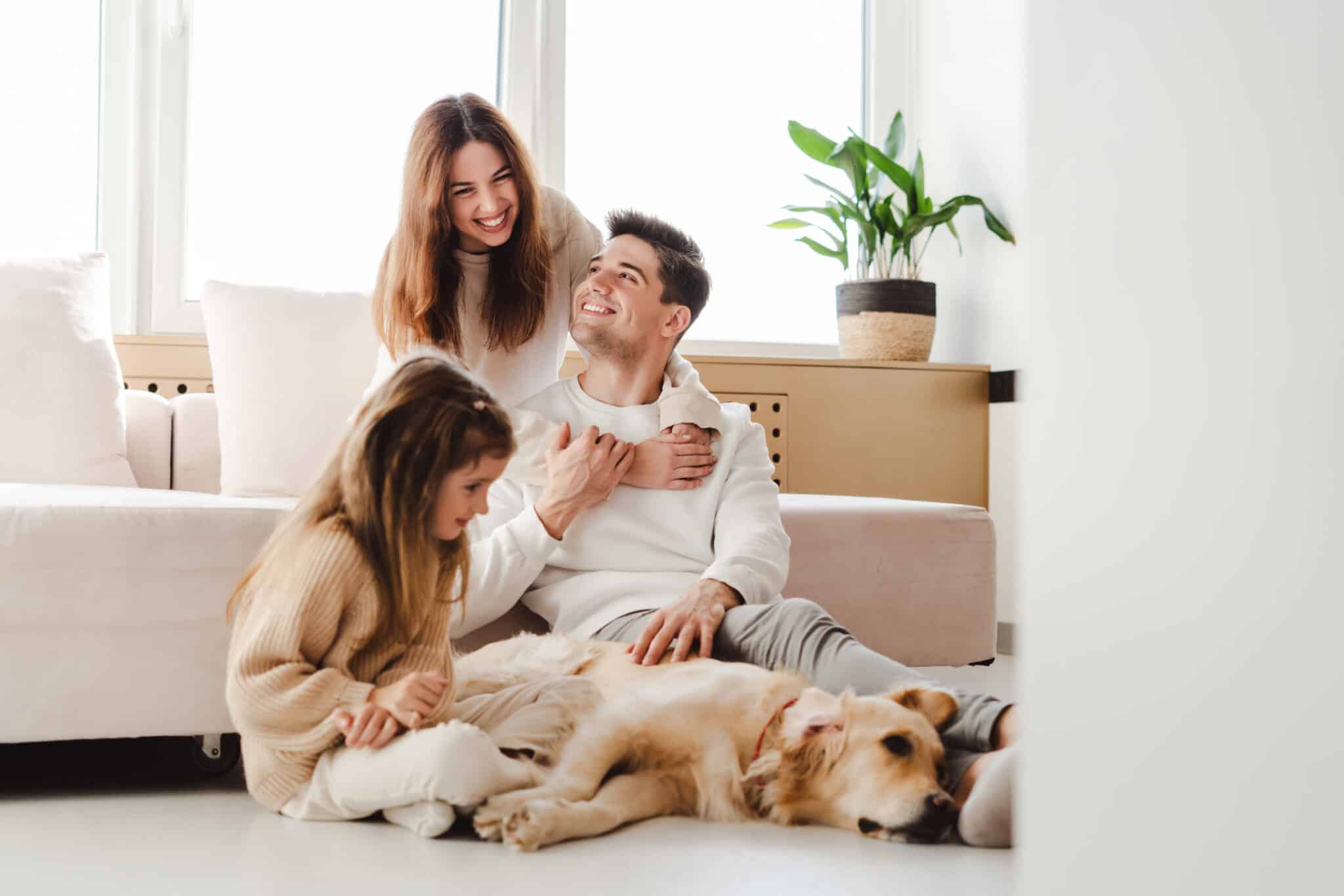 Smiling beautiful family, young mother, father and little daughter relaxing home cleaner air, Thermostats.