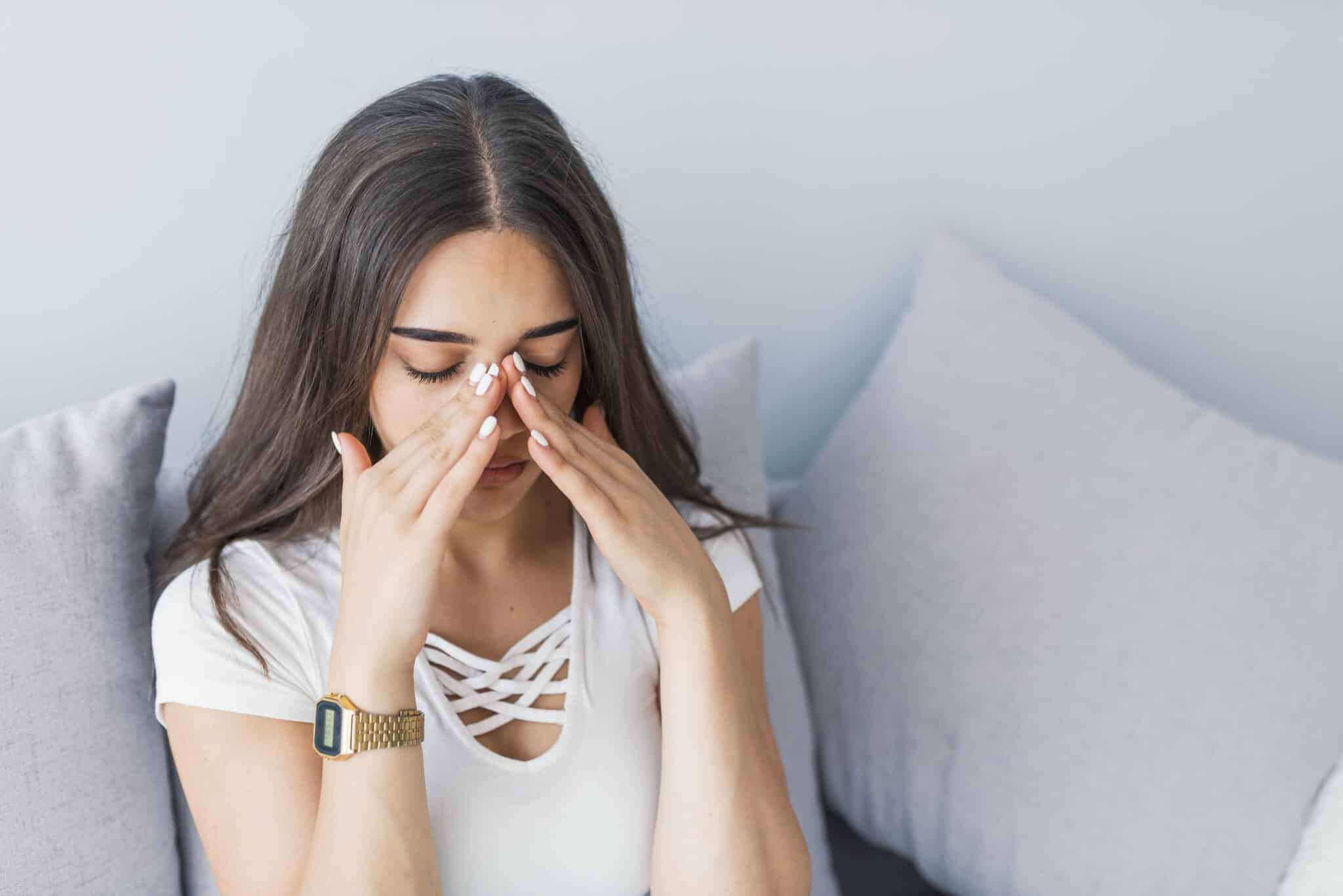 Sad woman holding her nose and head because sinus pain, Humidifier.