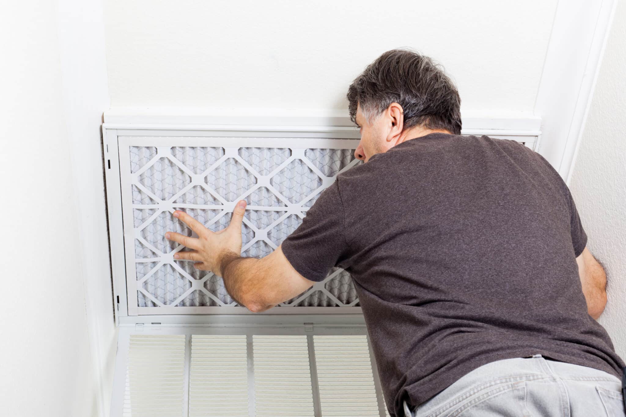 Man replacing a filter, Heating and Cooling.