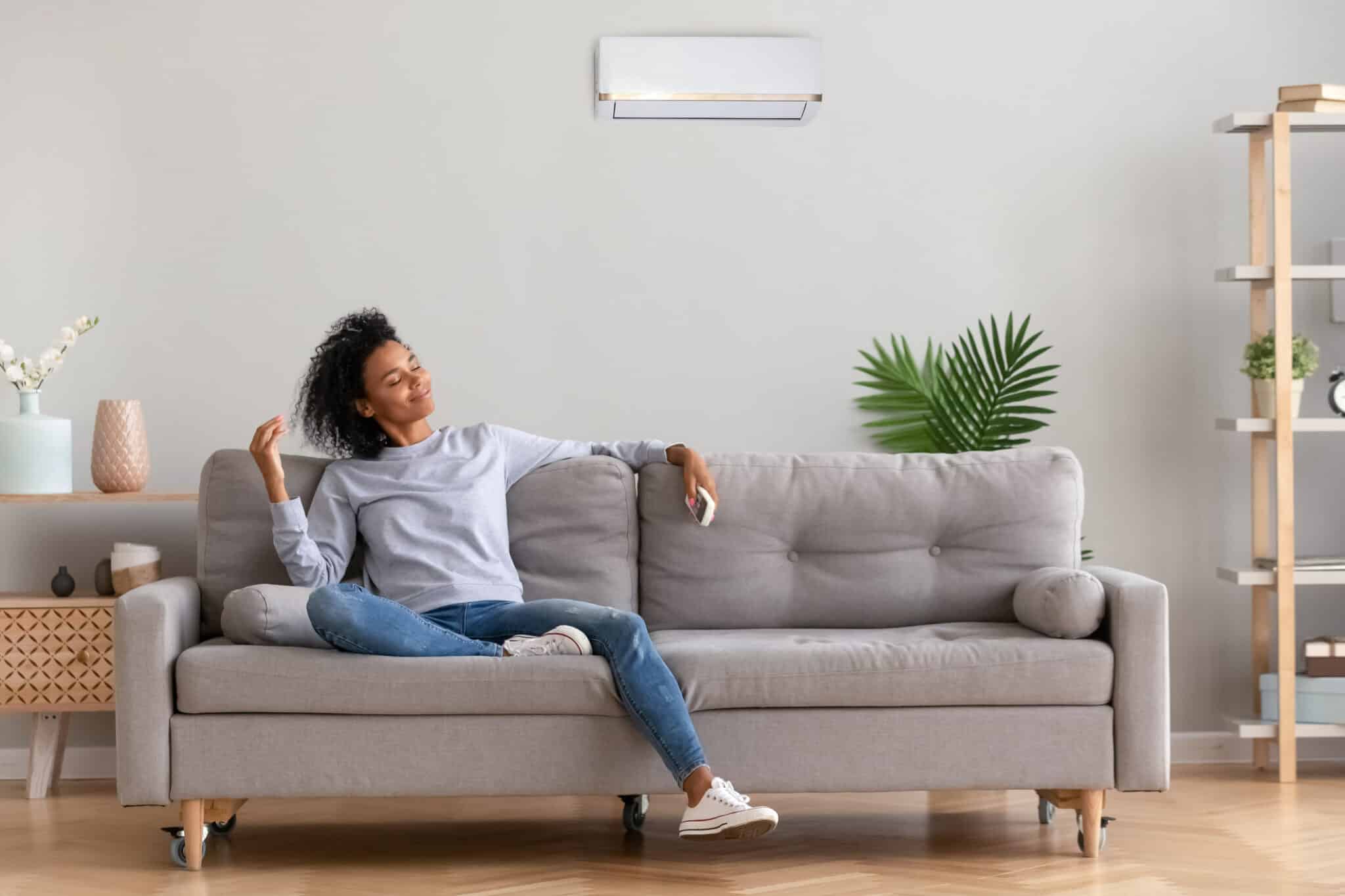 Relaxed woman sitting on couch breathing fresh air, Filter Care.